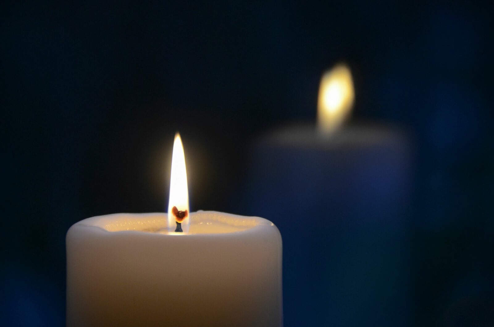 Close-up of a burning candle with a soft glow, creating a tranquil atmosphere.